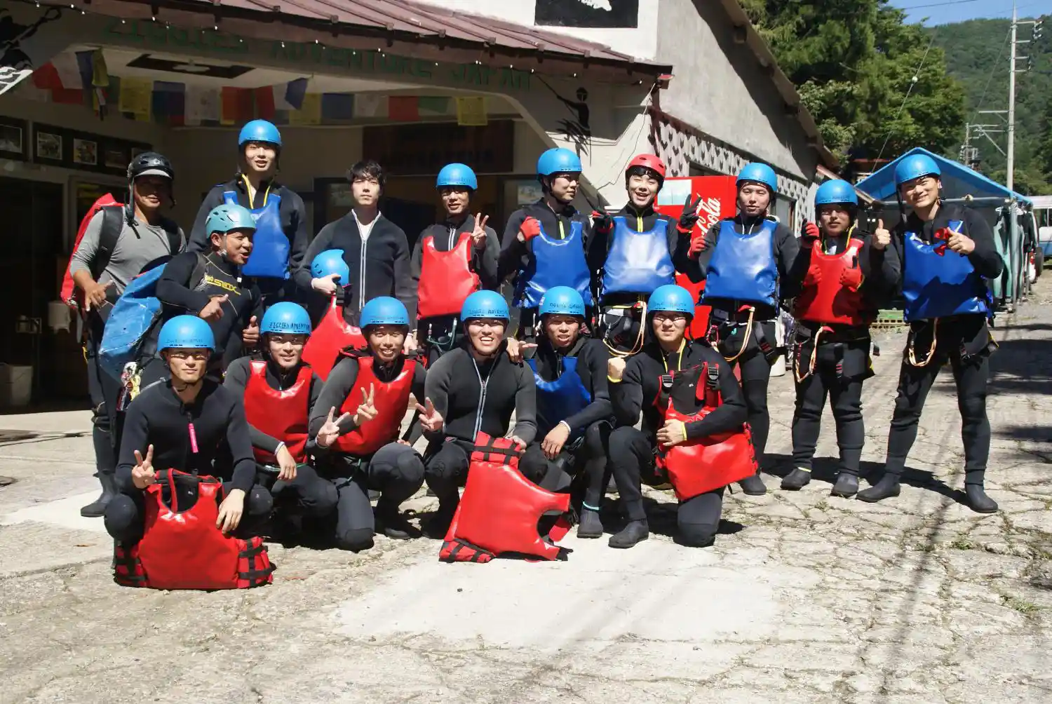 (水上)みなかみキャニオニンググループが完全な安全装備でみなかみ半日キャニオニングツアー開始前にベースキャンプで準備完了。Minakami canyoning group ready at base camp before starting minakami half day canyoning tour with complete safety equipment.